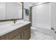 This bathroom features white tiled walls, marble floors, and a white basin at 2246 Fiesta Dr, Sarasota, FL 34231