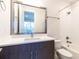 Modern bathroom with white countertop, decorative mirror, and tub with white tile surround at 2246 Fiesta Dr, Sarasota, FL 34231