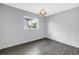 Bright bedroom featuring wood-look flooring, a window and a modern light fixture at 2246 Fiesta Dr, Sarasota, FL 34231