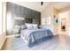 Modern bedroom with unique accent wall, gray tiled floors, comfortable bed, and light-filled ambiance at 2246 Fiesta Dr, Sarasota, FL 34231