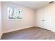 Bright, empty bedroom featuring a window, wood-look tile, and a double door closet at 2246 Fiesta Dr, Sarasota, FL 34231