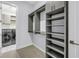 Spacious walk-in closet with custom shelving and hanging rods, plus a view of the laundry room at 2246 Fiesta Dr, Sarasota, FL 34231