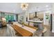 Open-concept dining area with modern lighting and seamless flow to the living room and kitchen at 2246 Fiesta Dr, Sarasota, FL 34231
