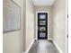 Inviting entryway features modern door with glass panes and stylish gray wood-look tile flooring at 2246 Fiesta Dr, Sarasota, FL 34231
