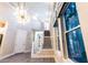 Bright foyer with grand staircase, wood-look tile floor, and decorative light fixture at 2246 Fiesta Dr, Sarasota, FL 34231
