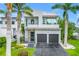 Modern two-story home boasts a sleek design, two-car garage and lush tropical landscaping at 2246 Fiesta Dr, Sarasota, FL 34231