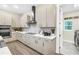 Well-lit kitchen with stainless steel appliances, stone countertops, and convenient access to laundry room at 2246 Fiesta Dr, Sarasota, FL 34231