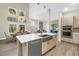 Modern open-concept kitchen island with stainless steel appliances, sleek cabinetry, and dining area at 2246 Fiesta Dr, Sarasota, FL 34231