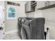 Laundry room showcases modern washer and dryer set, upper cabinets, and a 