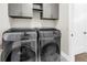 Modern laundry room features gray cabinets and a full-size, front-load washer and dryer set at 2246 Fiesta Dr, Sarasota, FL 34231