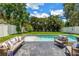 Backyard pool features comfortable seating and lush landscaping for ultimate relaxation and privacy at 2246 Fiesta Dr, Sarasota, FL 34231