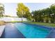 A backyard in-ground swimming pool features blue tile trim and tropical landscaping at 2246 Fiesta Dr, Sarasota, FL 34231