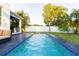 Backyard in-ground swimming pool with outdoor kitchen and tropical landscaping at 2246 Fiesta Dr, Sarasota, FL 34231