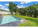 Stunning backyard pool surrounded by tropical palm trees and well-manicured green grass at 2246 Fiesta Dr, Sarasota, FL 34231