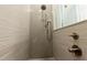 Modern bathroom featuring a tiled shower with rainfall shower head and bronze fixtures at 2246 Fiesta Dr, Sarasota, FL 34231