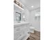 Bathroom features a modern vanity with a white countertop, a sleek mirror, and a toilet with wood-look flooring at 2514 Ohio S Ct, Gulfport, FL 33707
