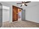 Bright bedroom with wood accent wall, a ceiling fan, and wood-look floors at 2514 Ohio S Ct, Gulfport, FL 33707
