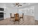 Dining room area featuring modern wood floors, vintage wood table and chairs open to a kitchen and living area at 2514 Ohio S Ct, Gulfport, FL 33707