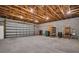 Spacious garage interior featuring exposed wood trusses, concrete block walls, and a roll-up garage door at 2514 Ohio S Ct, Gulfport, FL 33707