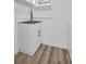 Bright laundry room features a stainless steel sink with white cabinets and wood-look vinyl flooring at 2514 Ohio S Ct, Gulfport, FL 33707