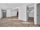 Open concept area with hardwood floors, grey entry door and view into the kitchen and dining area at 2514 Ohio S Ct, Gulfport, FL 33707