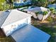 Aerial view of a home and detached garage featuring large driveway, palm trees and lush landscaping at 2514 Ohio S Ct, Gulfport, FL 33707