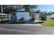 Charming home exterior with a carport, manicured lawn, and mature trees in the community at 27466 Us Highway 19 N # 97, Clearwater, FL 33761