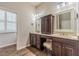 Bathroom featuring double sinks, dark cabinetry, marble counters and wood look tile floor at 3815 Gaviota Dr, Sun City Center, FL 33573