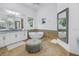 Bright bathroom featuring dual sinks, a soaking tub, a walk-in shower and a large mirror at 751 34Th Ne Ave, St Petersburg, FL 33704