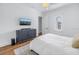 Bedroom with hardwood floors, a white bed, a blue dresser, and a TV mounted on the wall at 751 34Th Ne Ave, St Petersburg, FL 33704