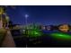 Night view of private boat dock with lift, illuminated by green lights and the American flag at 751 34Th Ne Ave, St Petersburg, FL 33704