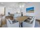 Open-concept dining area featuring a modern chandelier, an oversized table and a beach-themed painting at 751 34Th Ne Ave, St Petersburg, FL 33704