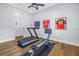 Home gym with treadmill, rowing machine, dark floors and sports memorabilia on the walls at 751 34Th Ne Ave, St Petersburg, FL 33704