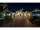 Stunning home exterior at night, featuring a brick driveway and lush landscaping with tropical palm trees at 751 34Th Ne Ave, St Petersburg, FL 33704