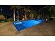 Backyard view of a rectangular pool, spa, and fire pit area surrounded by palm trees at night at 751 34Th Ne Ave, St Petersburg, FL 33704