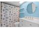 Charming blue bathroom with nautical-themed shower curtain, vanity, and a round mirror at 1033 Bowsprit Ln # 1406, Holiday, FL 34691