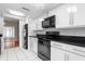 Well-lit kitchen featuring stainless steel appliances, and white cabinets at 1033 Bowsprit Ln # 1406, Holiday, FL 34691