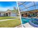 Well-maintained single-story home with a two-car garage, lush lawn, and a screened-in pool and outdoor kitchen at 2109 Elmwood Ct, Plant City, FL 33563