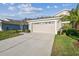 Attractive single-story home with a two-car garage, pretty landscaping, and sunny skies at 2932 Tanglewylde Dr, Land O Lakes, FL 34638