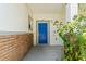 Close-up of the front door with a blue door, brick accent wall and updated light fixture at 3611 19Th N St, St Petersburg, FL 33713