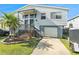 Charming two-story home featuring a front yard with a driveway and a downstairs garage at 7029 Oakwood Dr, New Port Richey, FL 34652