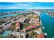 Breathtaking aerial view of condo complex, near Gulf Coast, with lush landscaping, water access, tennis courts, and parking at 8711 Blind Pass Rd # 307A, St Pete Beach, FL 33706