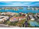 Aerial view of waterfront condos with a serene waterway and cityscape backdrop, lush landscaping, and ample parking at 8711 Blind Pass Rd # 307A, St Pete Beach, FL 33706