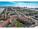 Scenic aerial view of condo with lush landscaping, tennis courts, serene pond with fountain, and convenient parking at 8711 Blind Pass Rd # 307A, St Pete Beach, FL 33706