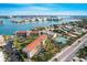 Stunning aerial view of waterfront condos with a serene bay and cityscape backdrop, lush landscaping, and ample parking at 8711 Blind Pass Rd # 307A, St Pete Beach, FL 33706