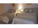 Comfortable second bedroom with two twin beds, accent lamps, and soft blue bedding, perfect for guests at 20040 Gulf Blvd # 302, Indian Shores, FL 33785