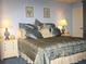 Cozy main bedroom with blue walls, accent lamps, and decorative bedding on the king-sized bed at 20040 Gulf Blvd # 302, Indian Shores, FL 33785