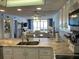 Bright kitchen showcasing granite countertops and open layout to living area with sliding glass doors to beach view at 20040 Gulf Blvd # 302, Indian Shores, FL 33785