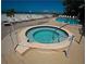 Well-maintained outdoor pool area with a hot tub and lounge chairs overlooking the ocean and beach at 20040 Gulf Blvd # 302, Indian Shores, FL 33785