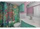 Colorful bathroom featuring an ornamented vanity, stylish mirror, artistic shower curtain, and a storage cabinet at 4140 55Th N St # 1211, Kenneth City, FL 33709